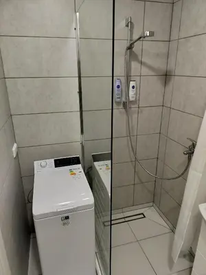 a shower with a glass door next to a toilet at Apartamentai dviems Ignalinoje in Ignalina