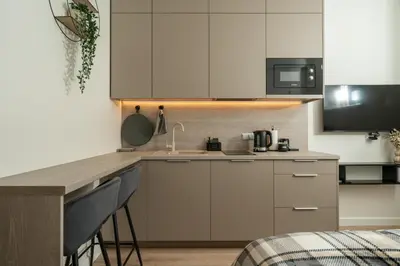 a kitchen with white cabinets and a sink at Studio Chic in Vilnius