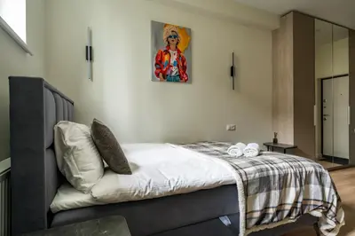 a bedroom with a bed with a picture on the wall at Studio Chic in Vilnius