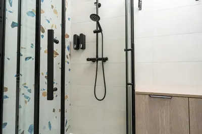 a shower with a shower head in a bathroom at Studio Chic in Vilnius