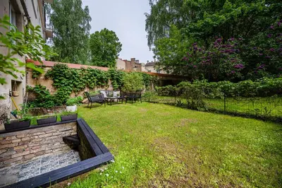 a backyard with a stone retaining wall and a garden at Premium City Center Jogailos Apartment in Vilnius