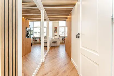 a hallway with a wooden ceiling and a living room at Cozy loft in city center in Vilnius