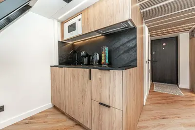 a kitchen with a wooden cabinet in a room at Cozy loft in city center in Vilnius