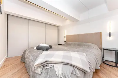a bedroom with a large bed and a table at Cozy loft in city center in Vilnius