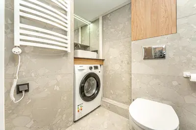 a bathroom with a washing machine and a toilet at Cozy loft in city center in Vilnius