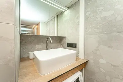 a bathroom with a white sink and a mirror at Cozy loft in city center in Vilnius
