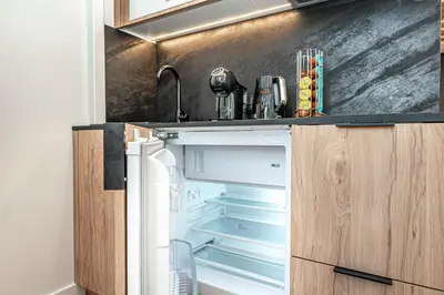 a refrigerator with its door open in a kitchen at Cozy loft in city center in Vilnius