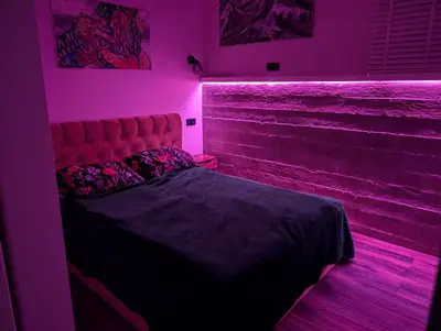 a bedroom with a bed with a pink lighting at Panoramic view home in Kaunas