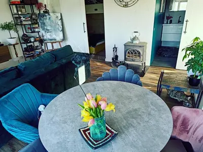 a living room with a table with a vase of flowers at Panoramic view home in Kaunas
