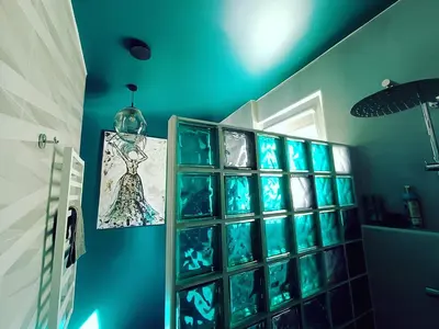 a blue bathroom with blue glass blocks on the wall at Panoramic view home in Kaunas