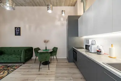 a kitchen with a green couch and a table at Shanti barracks apartment #2 by Polo Apartments in Kaunas