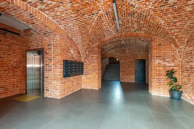 a brick hallway with a brick wall and a potted plant at Shanti barracks apartment #2 by Polo Apartments in Kaunas