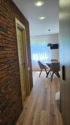 a room with a brick wall and a table and chairs at Savannah Ateities Apartamentai in Panevėžys