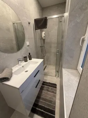 a bathroom with a sink and a shower with a mirror at Žilina in Marijampolė