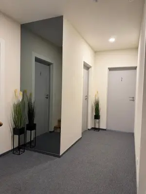a hallway with a mirror and two plants at Žilina in Marijampolė
