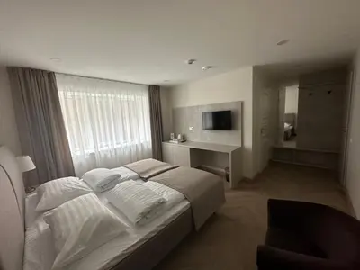 a bedroom with a large bed and a desk in it at Žilina in Marijampolė