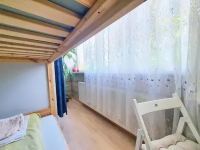 a small room with a window and a chair at Tokyo Vibes - Private Sleeping Pods Hostel, Self check-in in Vilnius