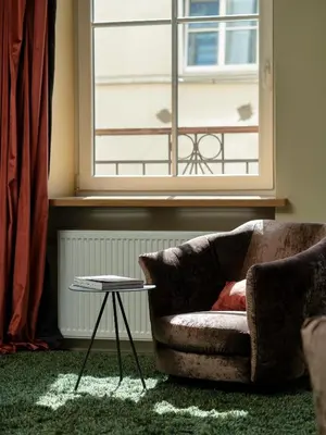 a couch and a table in a room with a window at Spacious, Very cosy, Stylish and Perfectly located in Vilnius