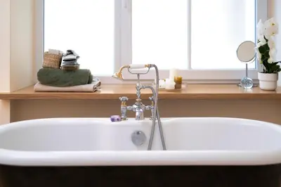 a white bath tub with a faucet in a bathroom at Spacious, Very cosy, Stylish and Perfectly located in Vilnius
