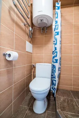 a bathroom with a white toilet and a light at Mini Studio Apartment in Kaunas