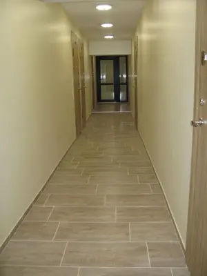 a hallway of an office building with a tile floor at Mini Studio Apartment in Kaunas