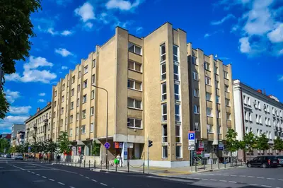a tall building on a city street with a blue sky at Mini Studio Apartment in Kaunas