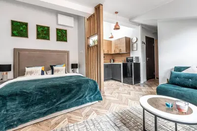 a bedroom with a large bed and a living room at Oldtown Apartment studio #D in Vilnius