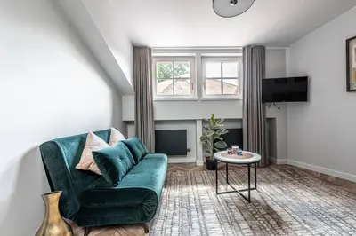a living room with a green couch and a table at Oldtown Apartment studio #D in Vilnius