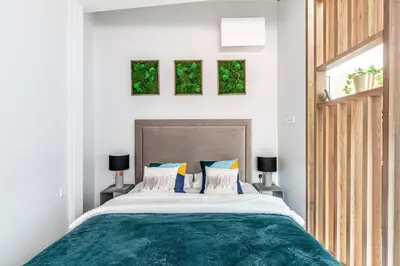 a bedroom with a large bed and two windows at Oldtown Apartment studio #D in Vilnius