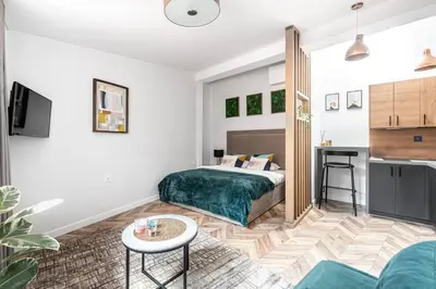 a living room with a bed and a kitchen at Oldtown Apartment studio #D in Vilnius