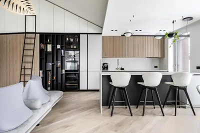 a kitchen with white cabinets and white stools at Penthouse in Old Vilnius in Vilnius