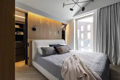 a bedroom with a bed and a large window at Penthouse in Old Vilnius in Vilnius