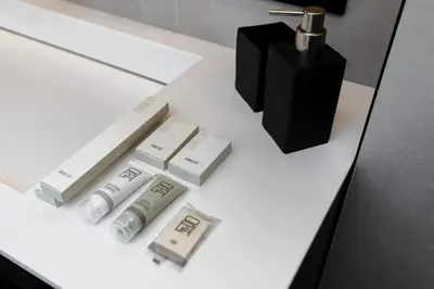 a white table with a bottle of lotion and a black box at Penthouse in Old Vilnius in Vilnius