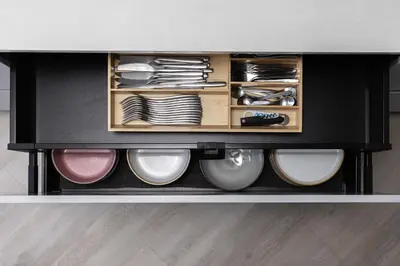 a black cabinet with plates and dishes at Penthouse in Old Vilnius in Vilnius