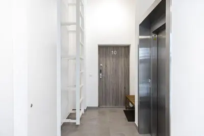 a hallway with a wooden door and shelves at Penthouse in Old Vilnius in Vilnius