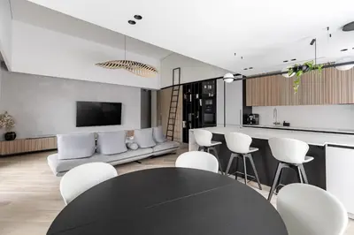 a living room with a black table and white chairs at Penthouse in Old Vilnius in Vilnius