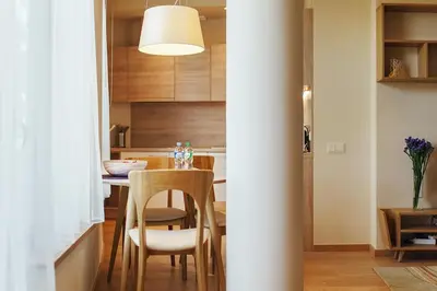 a kitchen and dining room with a table and chairs at Ballare Druskininkai in Druskininkai