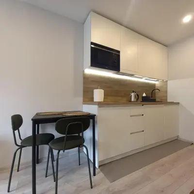 a small kitchen with a table and two chairs at Cozy small apartment #5A in Šiauliai