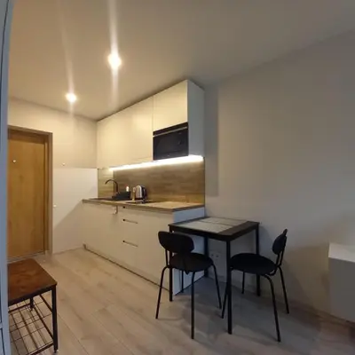 a kitchen with a table and chairs in a room at Cozy small apartment #5A in Šiauliai