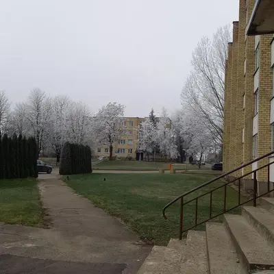 a park with trees and a building and a sidewalk at Cozy small apartment #5A in Šiauliai