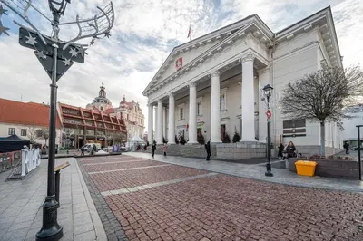 a large white building on a city street at Newly Furnished Vilnius Town Hall Apartments by Reside Baltic in Vilnius