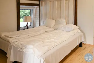 a large white bed in a room with a window at Uždubysio baidarės Sodyba už Dubysos in Ariogala