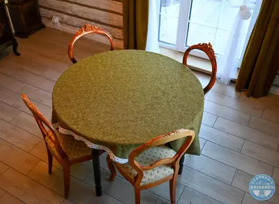a dining room table with two chairs and a green table at Uždubysio baidarės Šimtametė Rezidencija in Ariogala