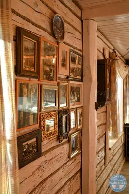 a wall of pictures on a wooden wall at Uždubysio baidarės Šimtametė Rezidencija in Ariogala