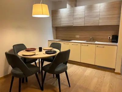 a kitchen with a table and chairs in a room at Vilniaus alėjos apartamentai in Druskininkai