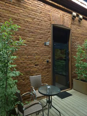 a patio with a table and chairs and a brick wall at Pilot Loft in Kaunas