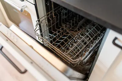 a dishwasher with a dish rack inside of it at Pilot Loft in Kaunas