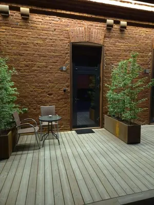 a patio with a table and chairs on a wooden deck at Pilot Loft in Kaunas
