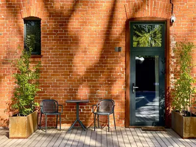 two chairs and a table in front of a brick building at thePilots in Kaunas