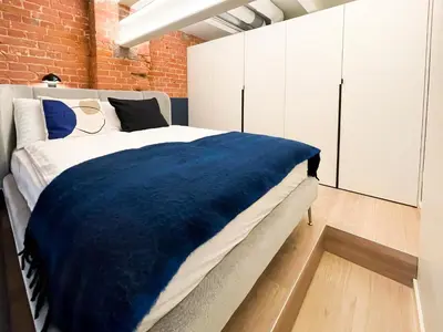 a bedroom with a bed and a brick wall at thePilots in Kaunas